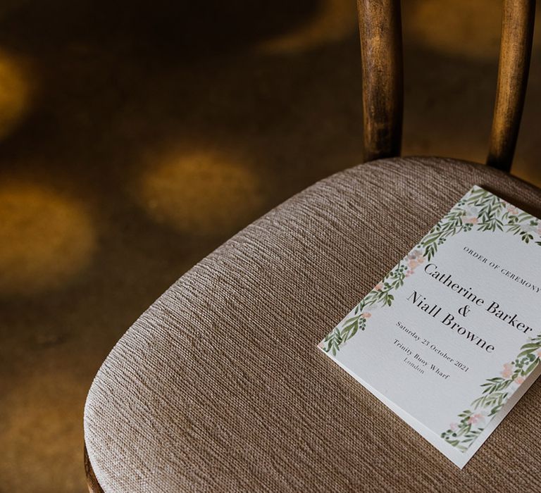 Order of ceremony booklets on the seats for wedding guests with leaf design and personal details 