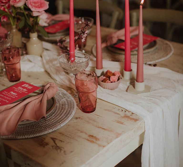 wedding table decor with cream table runner, wicker place mat, pink taper candles and pink on the day wedding stationery menu card