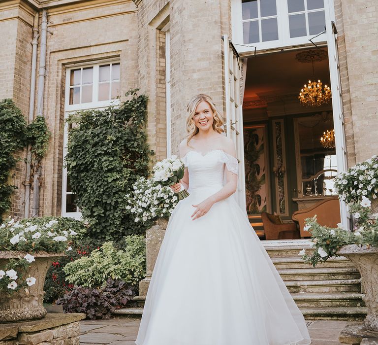 Bride in ballgown wedding dress holding white flower bouquet for Hedsor House wedding 