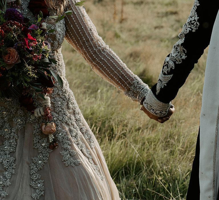 Bride & groom hold hands as they walk with one another on their wedding day