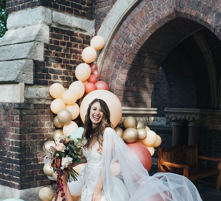 Bride in a ruffle wedding dress with a sheer lace cape and silver wedding heels 