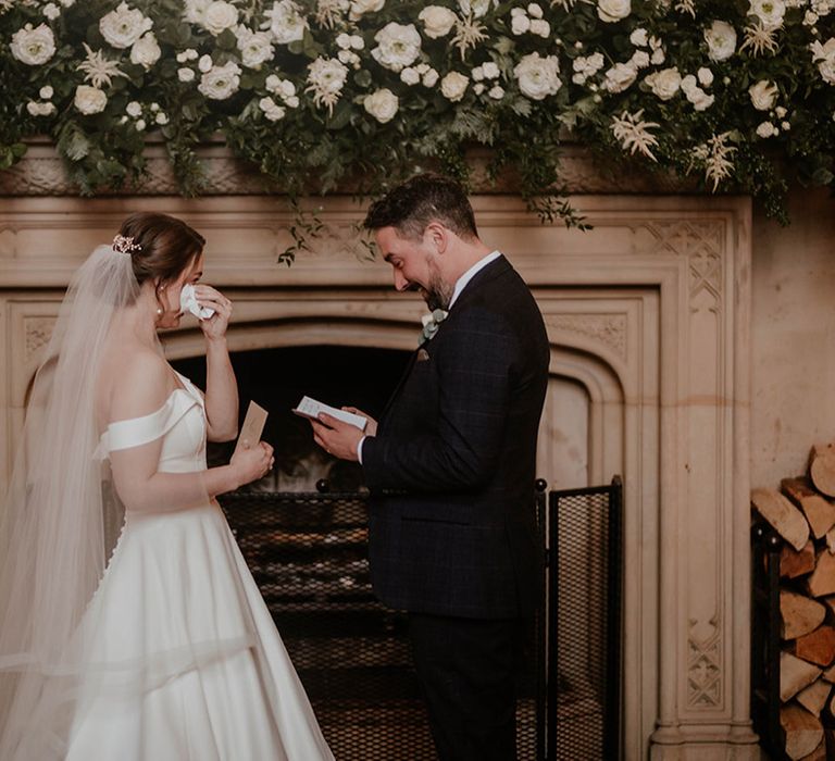 Bride wipes her eyes as the groom reads out his wedding vows for their wedding ceremony 