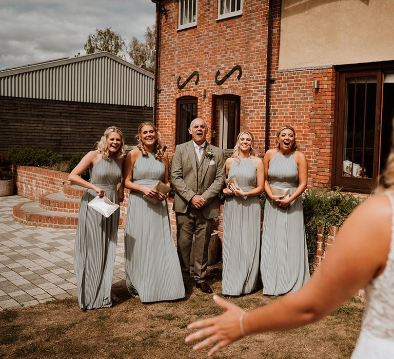 The father of the bride and the bridesmaids get their first look at the bride in her Christina K wedding dress 