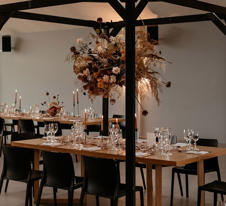 Black cabana over the main top table with dried flower decor and neutral colour palette with orange taper candles 