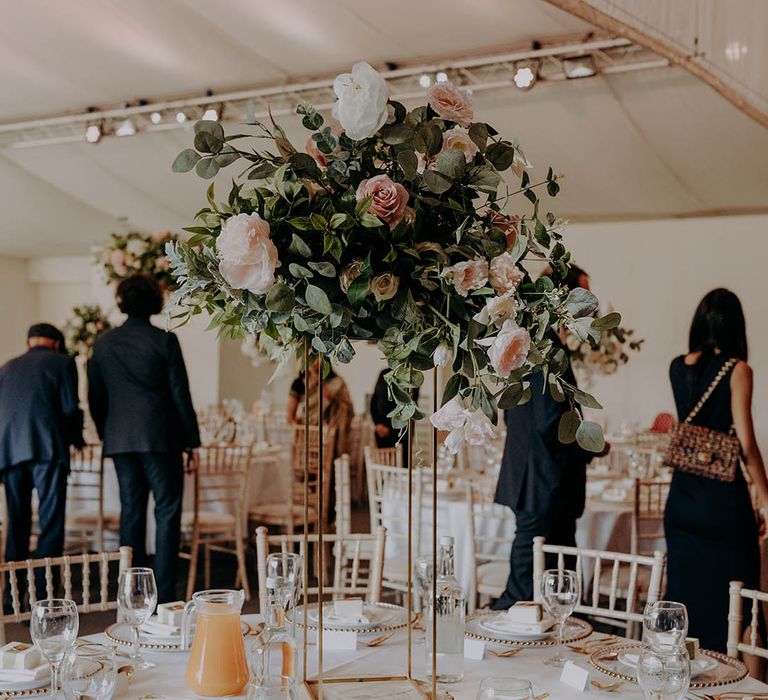 Large floral arrangement complete with green foliage and pastel pink roses for classic tablescape 