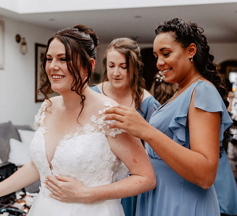 Bride in Suzanne Neville wedding dress with flower design with the bridesmaids in cornflower blue bridesmaid dresses 