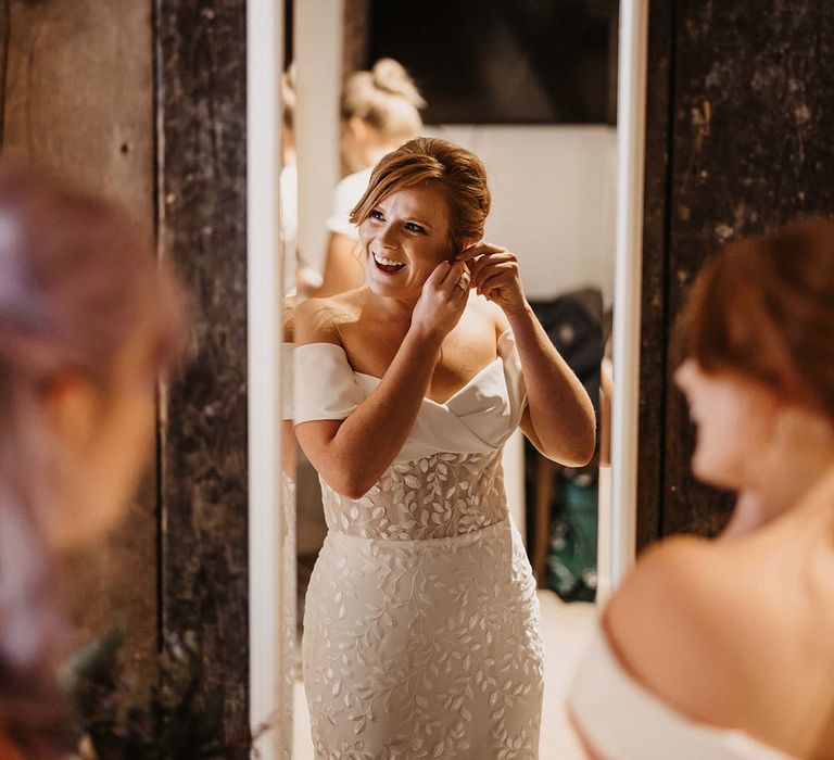 Bride wears appliqué Love Spell wedding dress with off-the-shoulder design and sheer bodice 