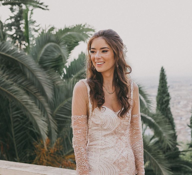 Bride with long hair in a bespoke gold sparkly wedding dress with illusion long sleeves