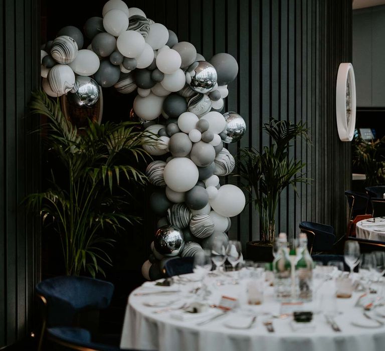 Grey, silver, white and black wedding balloon arch in The Gherkin wedding venue reception room