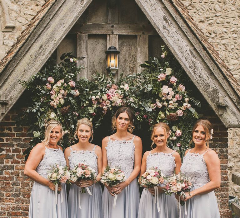 Pale blue bridesmaid dresses with lace detailing and ankle strap at church wedding 