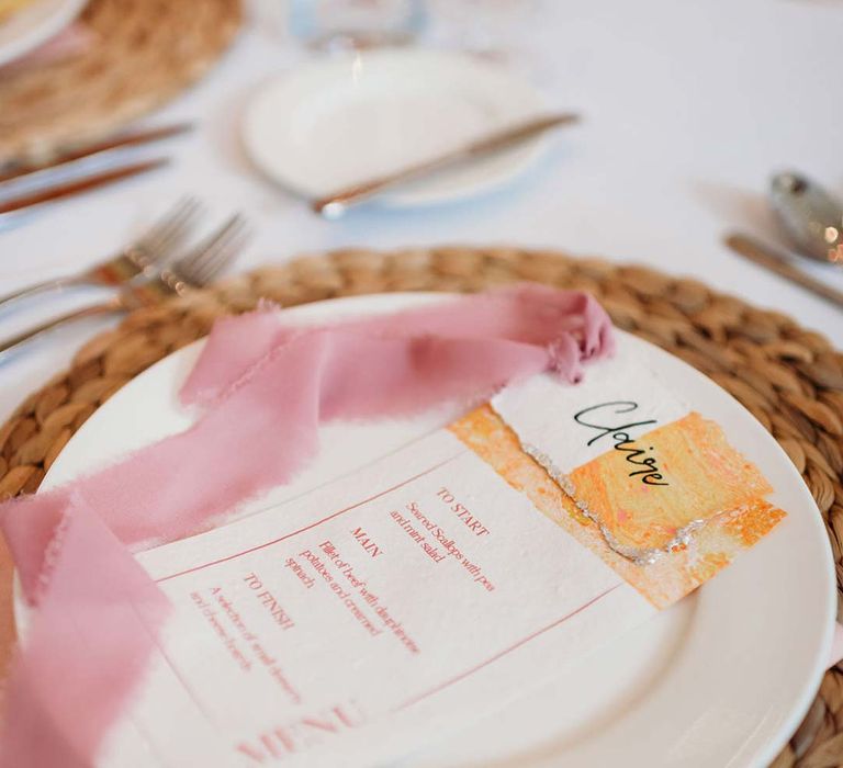 Seasonal flower inspired wedding menu with pink frayed ribbon on burlap wedding place mat at Merriscourt wedding 