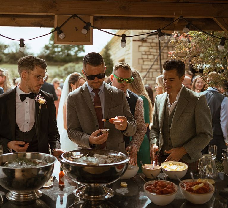 Wedding guests eat oysters for wedding food 