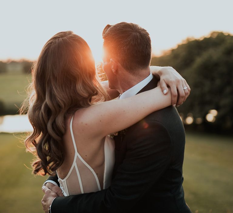 Golden hour wedding photo of the bride and groom looking out at the view 