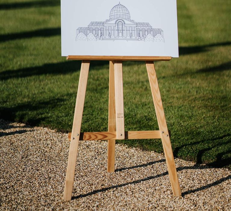 Minimalist monochrome wedding welcome sign on wooden easel at Syon Park wedding venue