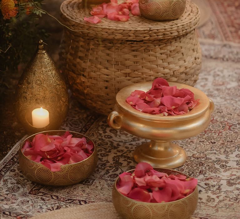 red petals for a Hindu wedding ceremony in a wicker basket with intricate gold lantern and pot 