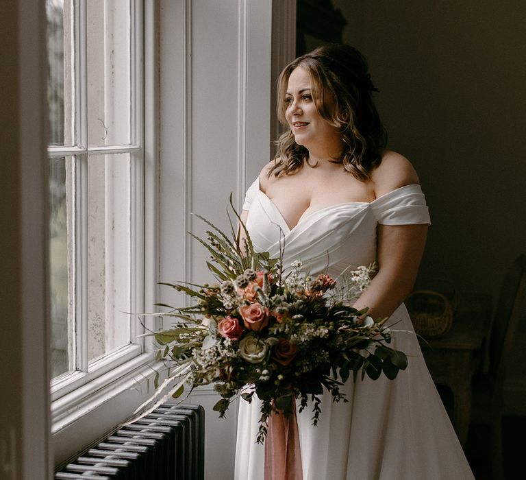 Bride in Madi Lane wedding dress holding pink wedding bouquet 