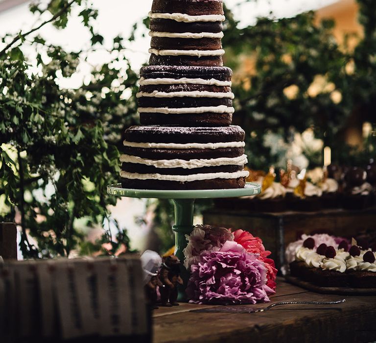 Chocolate sponge naked wedding cake with pink flower topper 