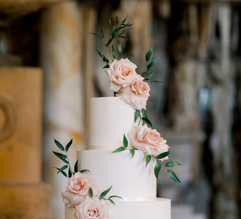 three tier white iced wedding cake with pink roses