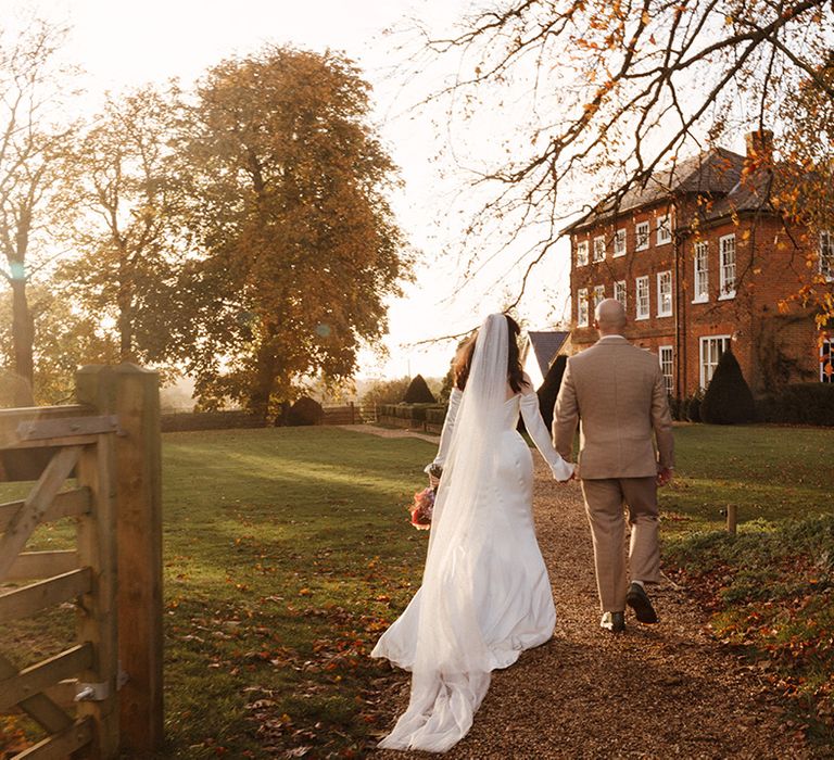 Sandon Manor wedding with classic wedding fashion with the bride in a satin wedding dress and groom in checkered suit 