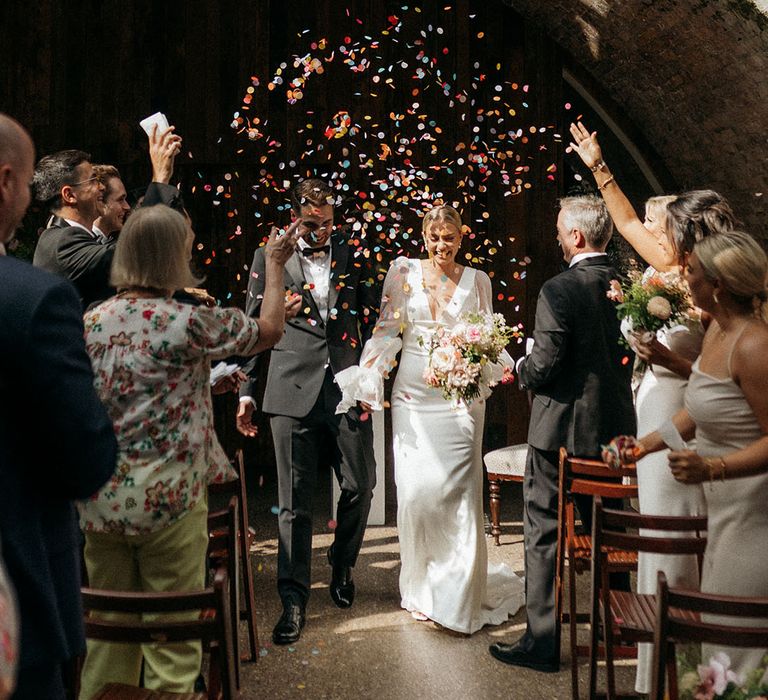 Bright and colourful confetti moment for the bride and groom at their retro glam wedding 