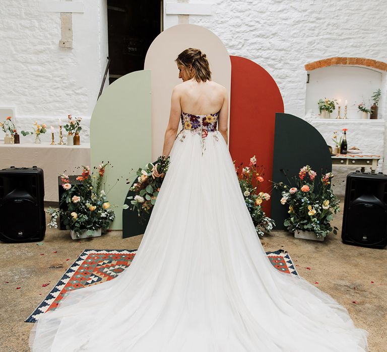 Bride in strapless floral wedding dress by Nicole Milano 