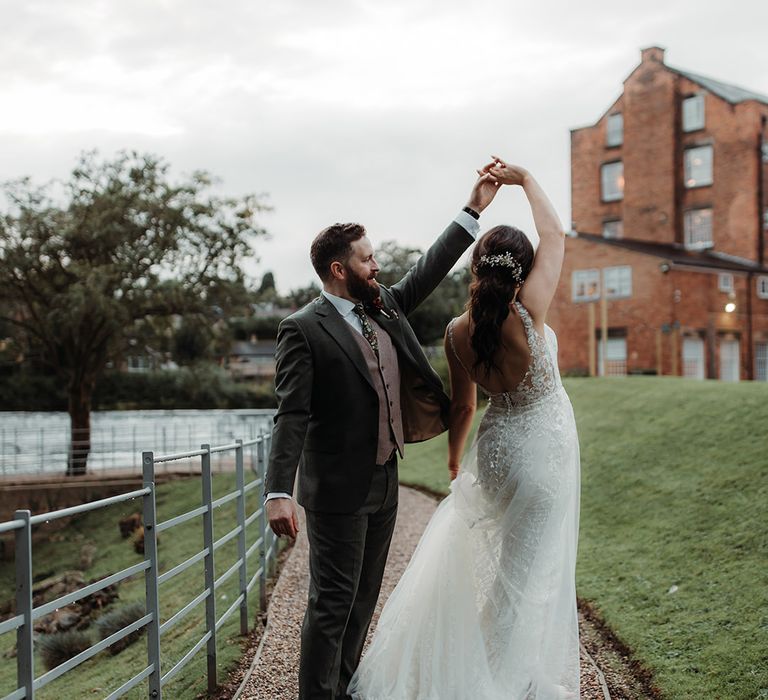 The groom in a green wedding suit dances with the bride at Derbyshire wedding 