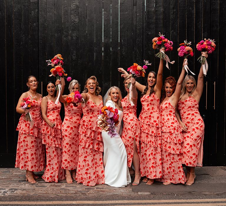 Bridal party wearing red and pink patterned bridesmaid dresses for contemporary city wedding