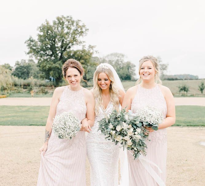 Bridal party portrait with bridesmaids in blush dresses and bride in Made With Love lace dress 