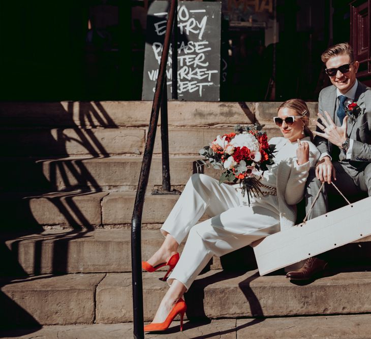 Stylish bride and groom showing off their wedding rings after their intimate micro wedding 