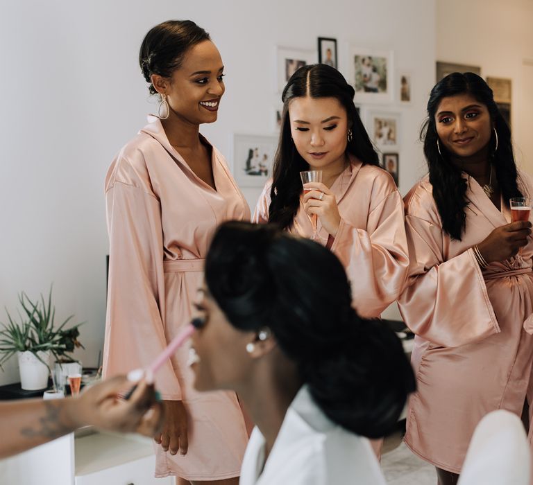 Bridesmaids in pink getting ready robes on the morning of the wedding 