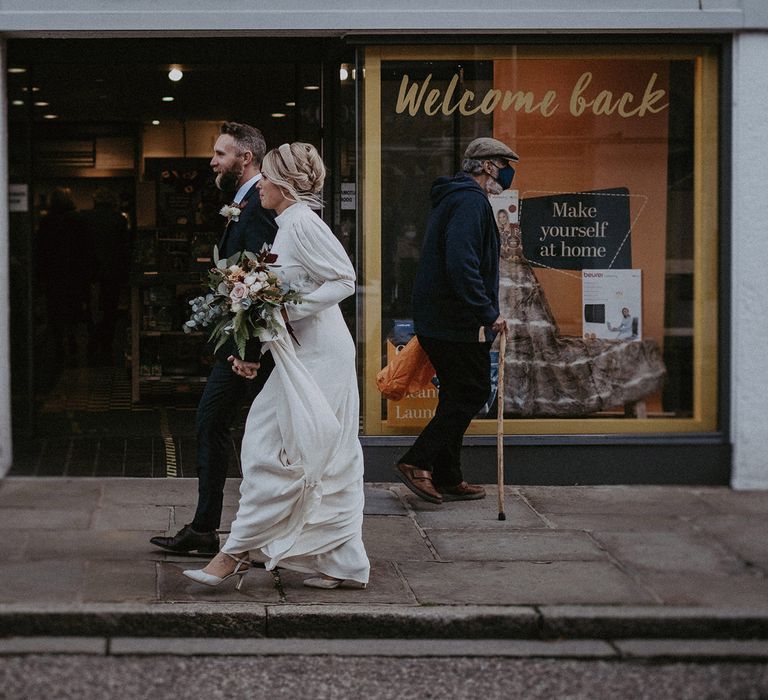 Bride and groom walking through the streets 