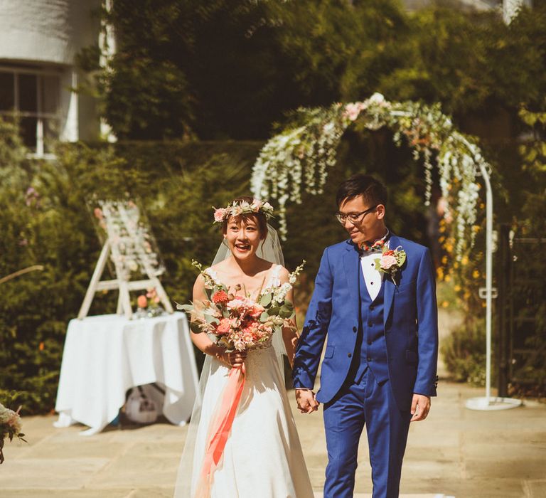 Bride and groom walking down the aisle together at outdoor ceremony 