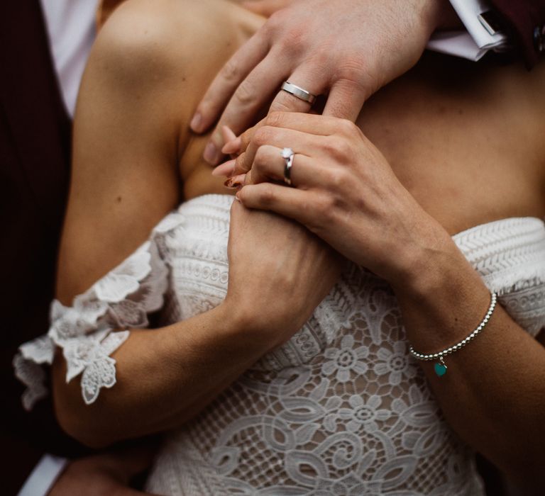 Bride and groom just married hold hands and show off wedding rings