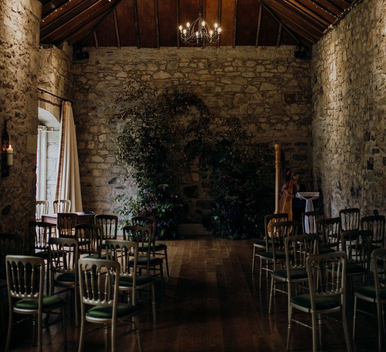 Kirknewton House Stables wedding barn interior with fairy lights and green chairs