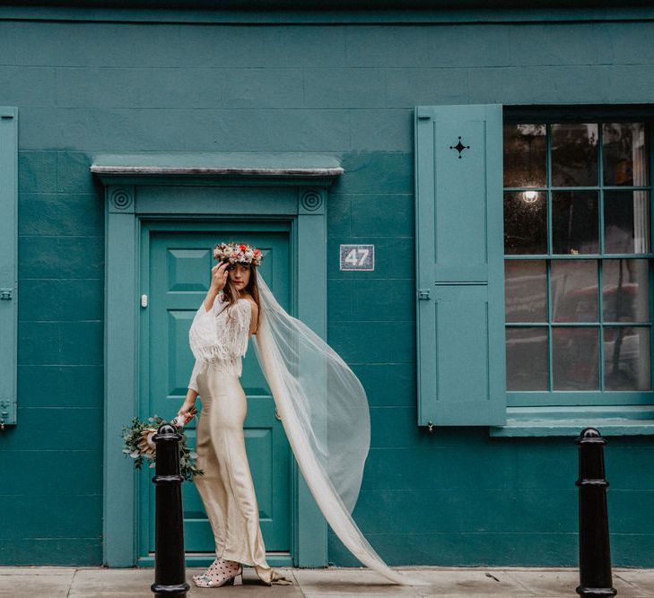 Bride poses against teal wall