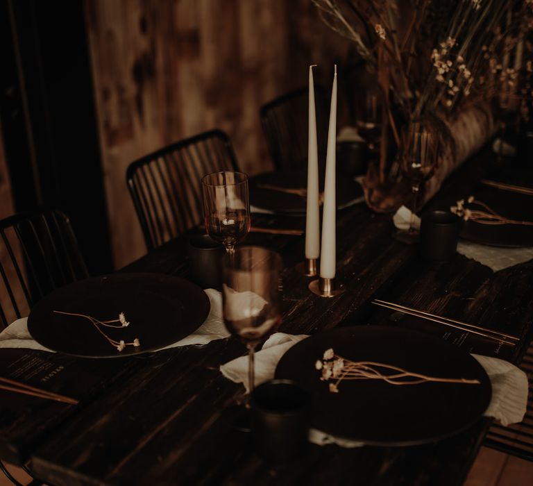 Wedding table decor with black wire chairs, copper candlesticks, taper candles and coloured goblets 