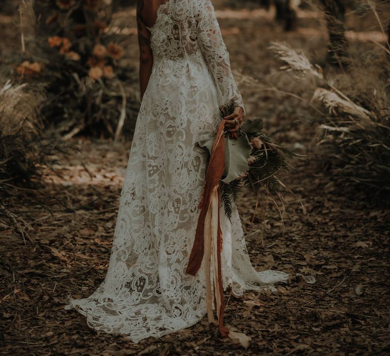 Bride in a lace one shoulder wedding dress with long sleeve 