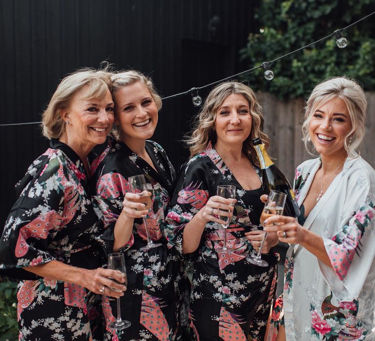 Bride gets ready with her bridesmaids wearing floral dressing gowns 