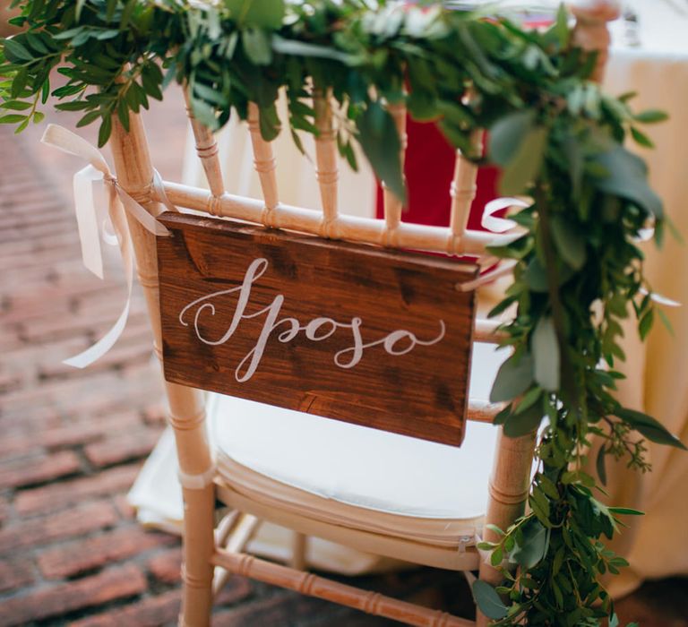 The groom's wedding chair with a wooden sign reading 'Sposo'