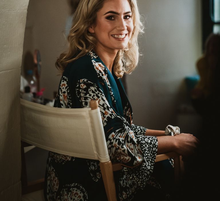 Bride smiles at camera on the morning of her wedding