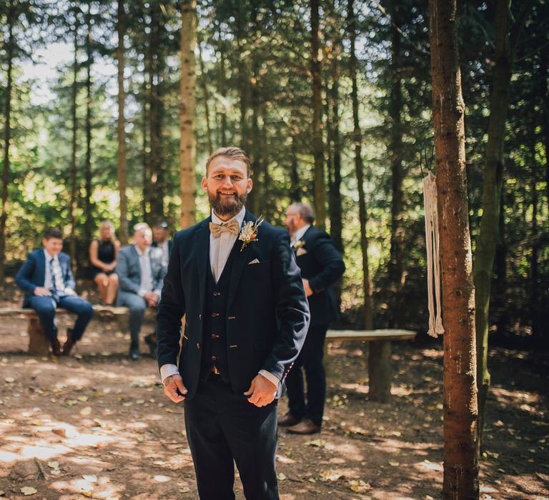 Groom waits smiling for bride on the day of his wedding