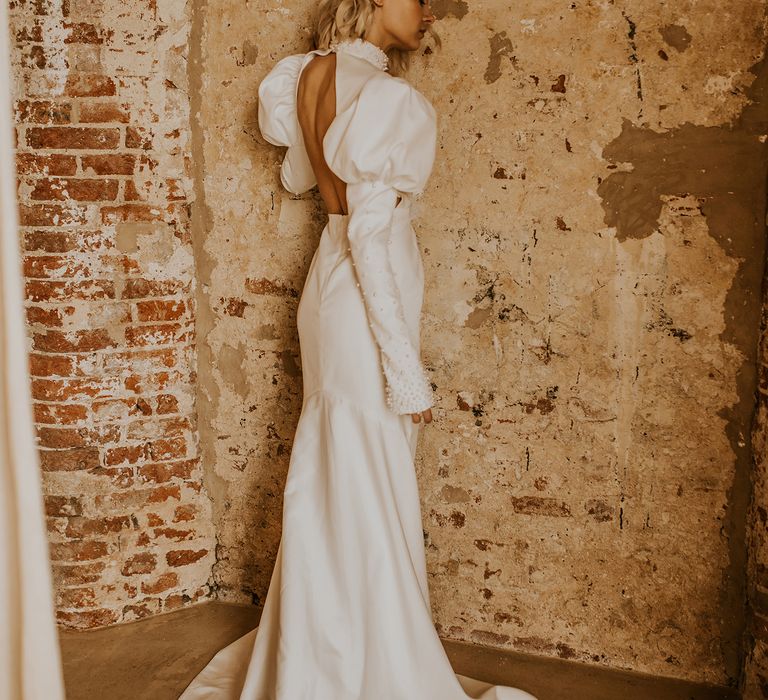 Bride in a fitted wedding dress with open back detail and puddle train at a bohemian luxe wedding 