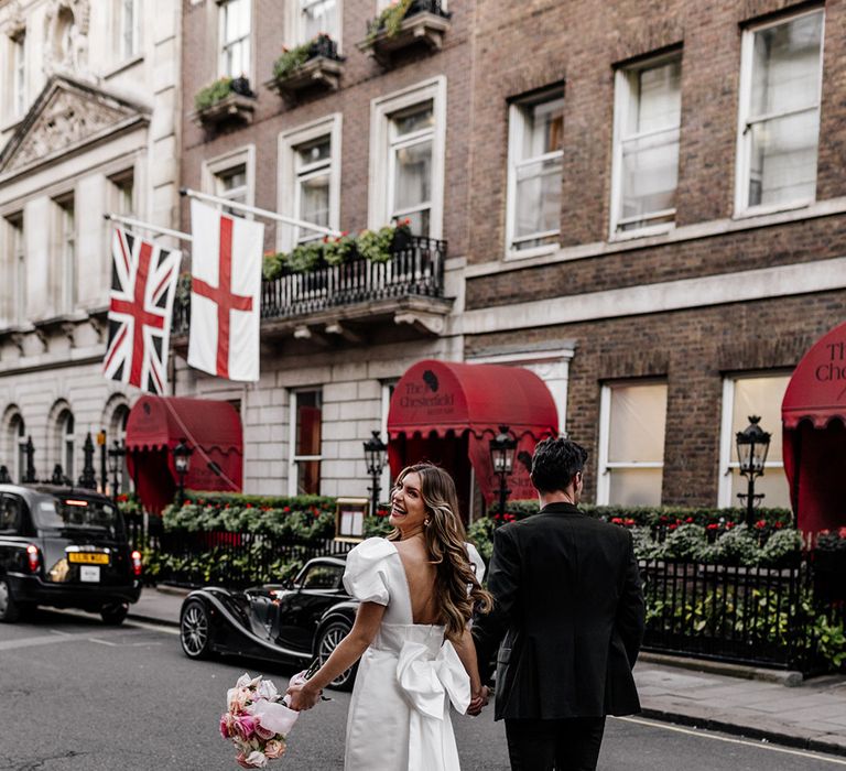 Stylish short wedding dress for city wedding with puff sleeves, low back and trailing bow detail