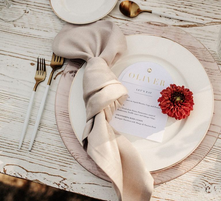 White and gold tableware with neutral linen napkins and single flower detail for finca wedding in Spain