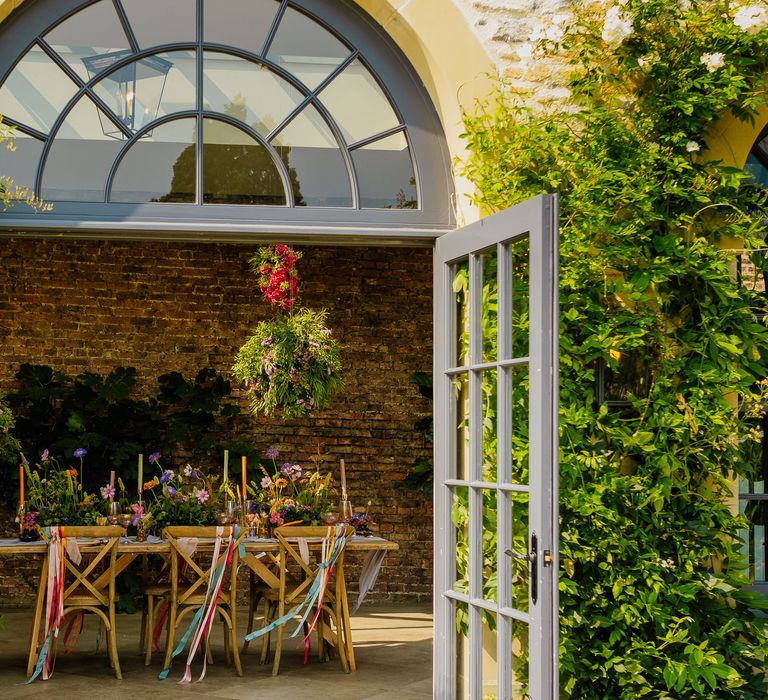 Fiesta theme wedding table decor with colourful ribbons, wildflowers and hanging baskets 