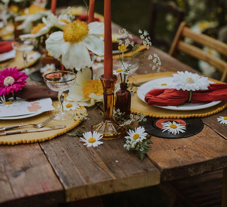 wedding table decor with brown candlestick holders, taper candles, wildflowers and yellow place mats 