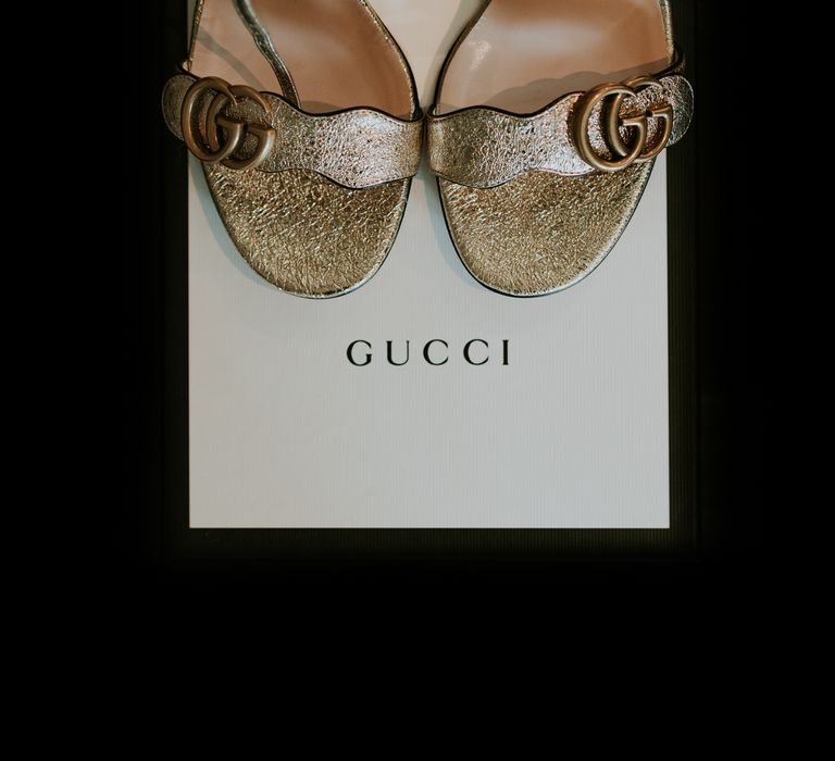 Gucci shoes in gold with GG symbol to the side of straps