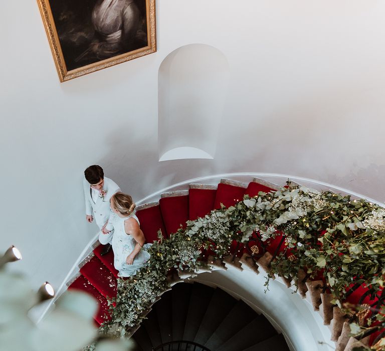 Bride & groom walk down the stairs on the day of their wedding