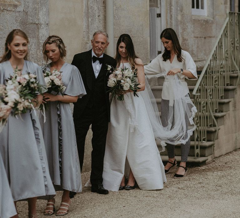 Bride lines up with bridesmaids before walk down the aisle at Elmore Court