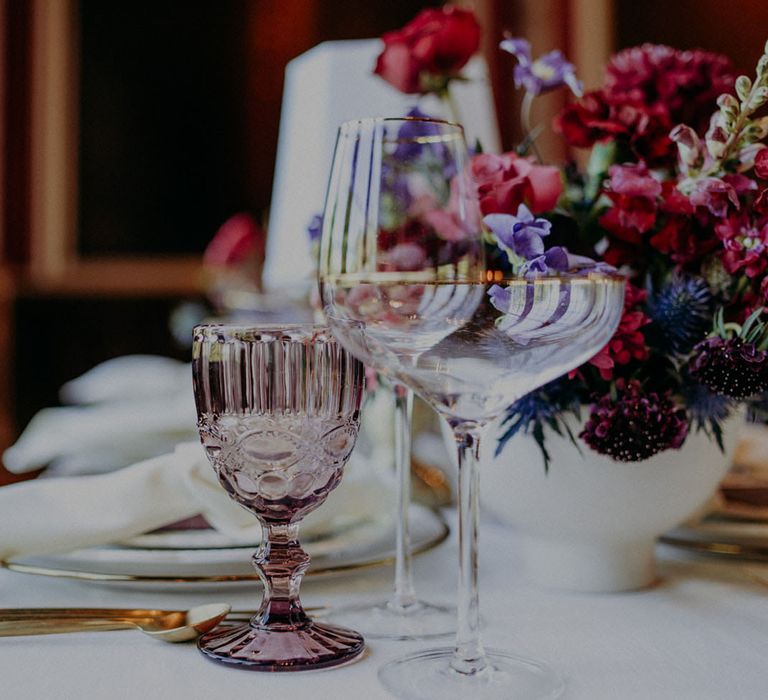 purple coloured goblet and gold rimmed coupe glass for jewelled coloured wedding inspiration 